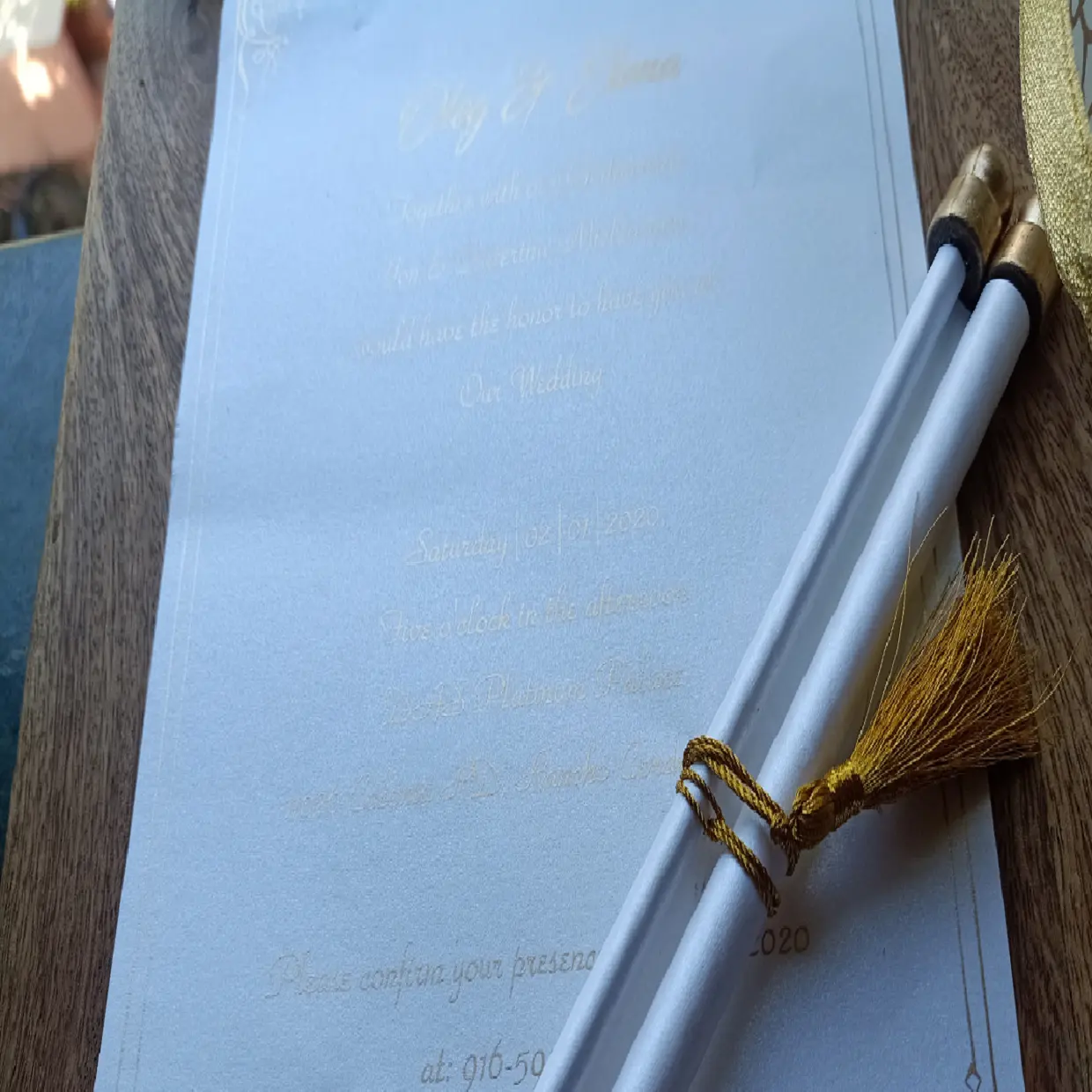 Пустые свадебные приглашения из прокрутки, включая коробки с лазерной гравировкой, наряду с золотыми стержнями прокрутки, кисточками и печатной бумагой с пустыми краями