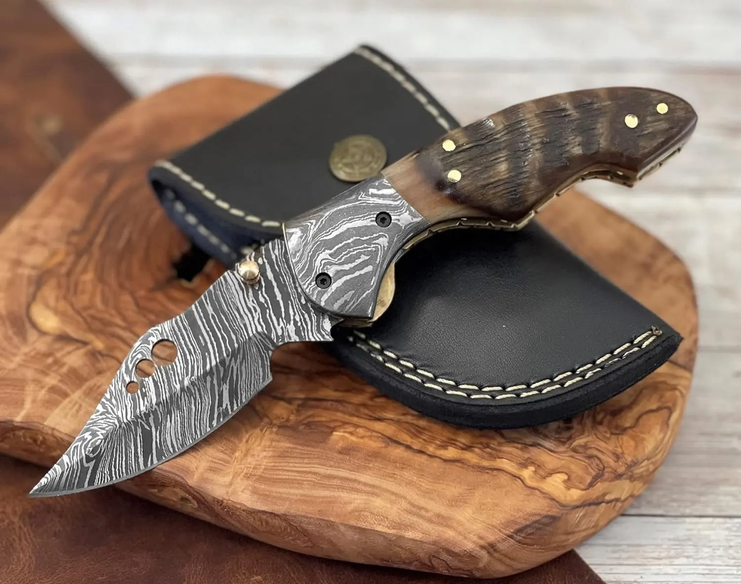 Custom handmade Damascus steel pocket knife 3 inch blade and handle ram horn with cork opener spring and fine leather sheath.