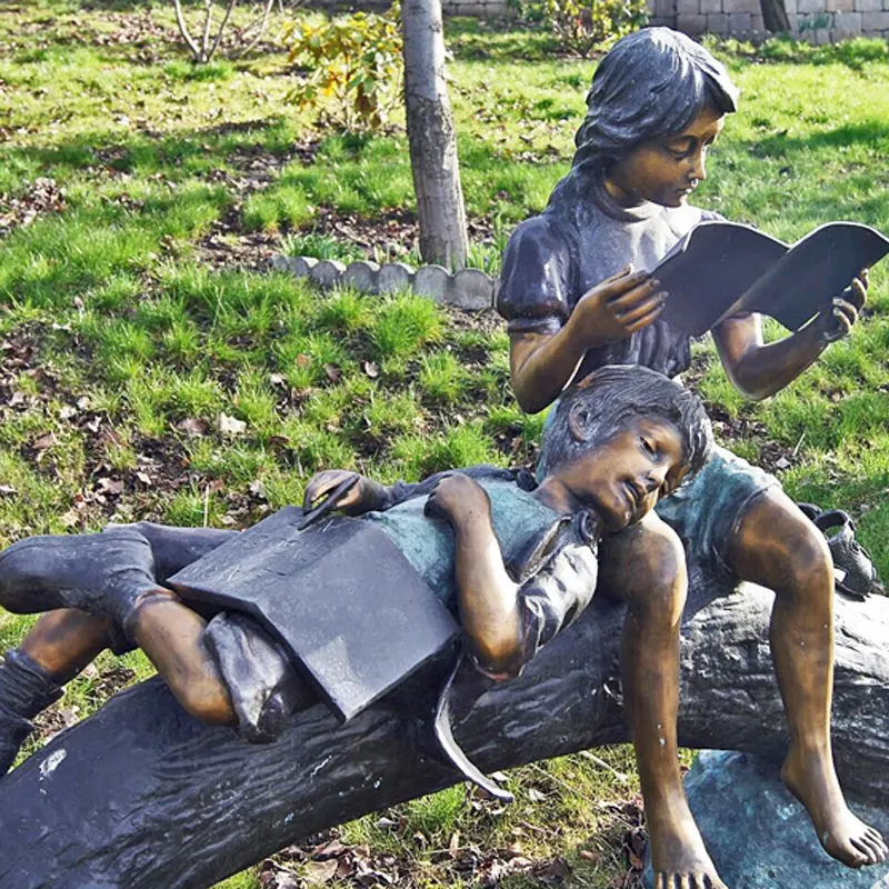 Scultura moderna del libro di lettura del ragazzo e della ragazza del bronzo a grandezza naturale della decorazione del giardino nel tronco