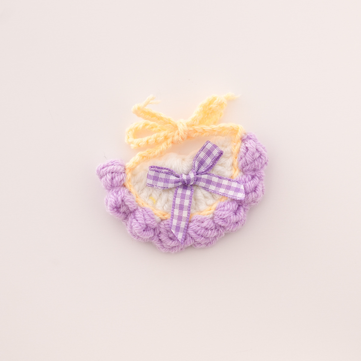 Bib with white background, purple trim, and purple bow