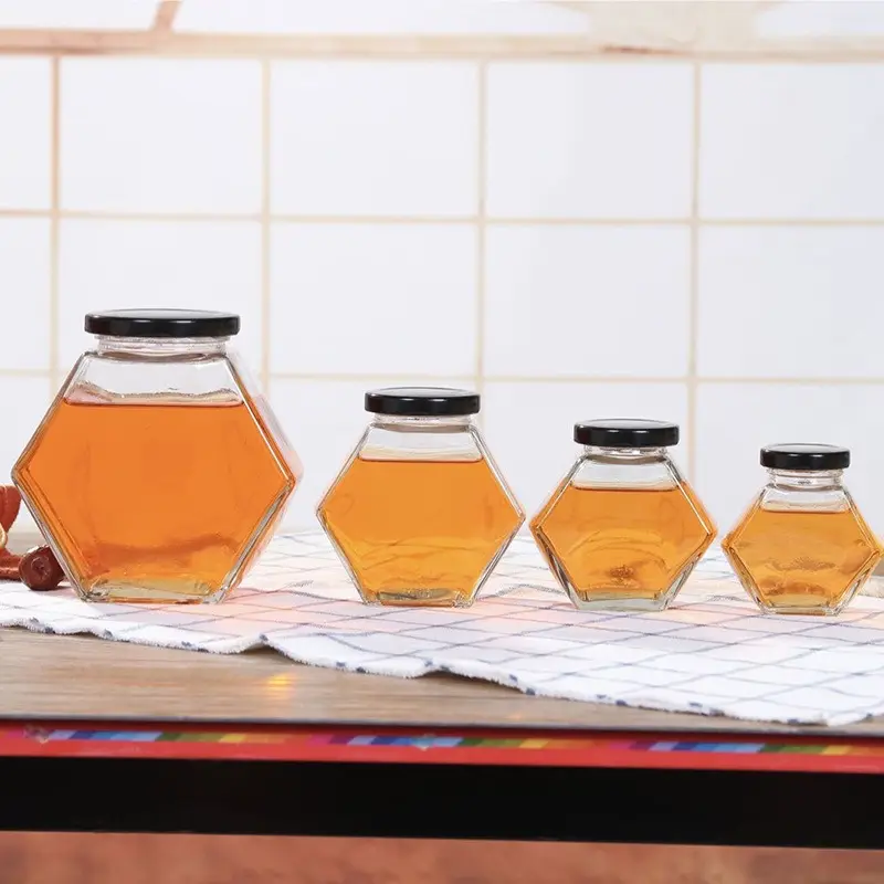 Venta directa de fábrica, contenedor de comida Hexagonal transparente de 300ml, tarro de vidrio de miel en escabeche con tapa de hojalata