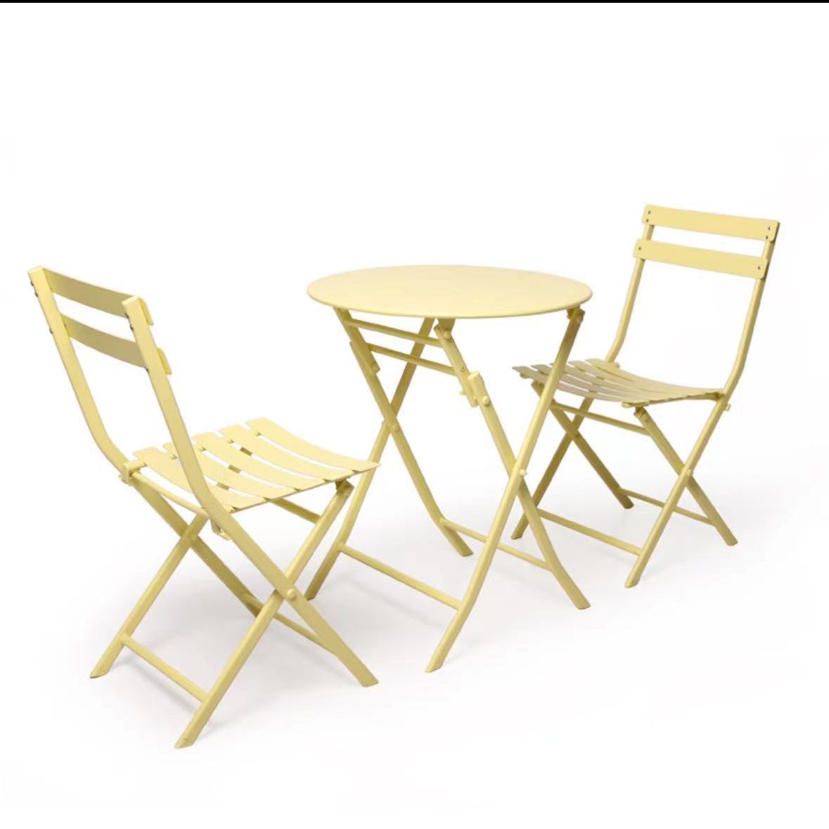 Ensemble comprenant 2 chaises en fer forgé jaune et 1 table ronde pliante.