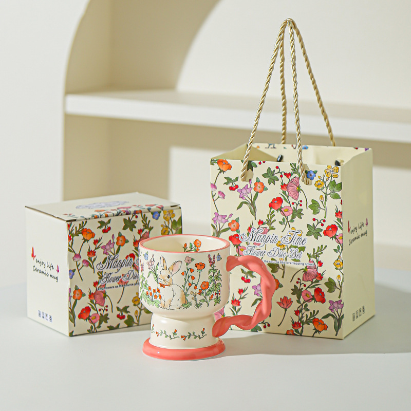 Tasse rose de lapin de buisson de fleur (tenu dans la main)