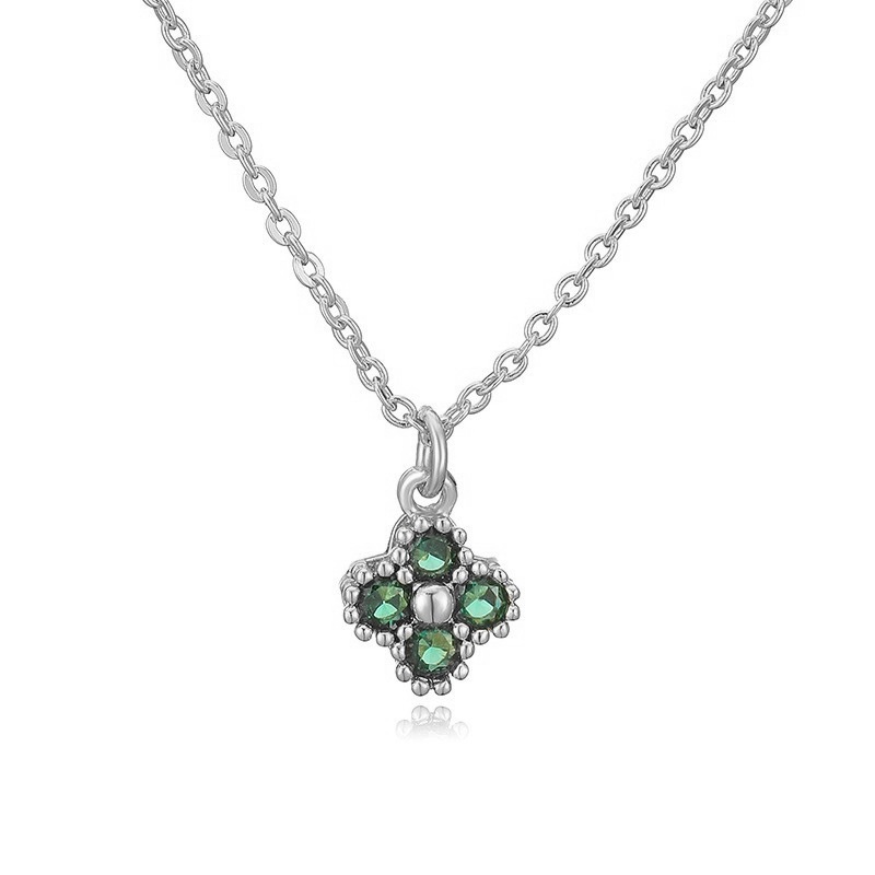 Collier en or blanc avec diamant vert, trèfle à quatre feuilles et pendentif en forme de "O".