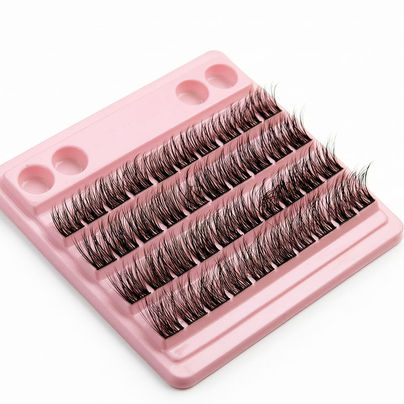Cils en bouquets noirs sur plateau rose