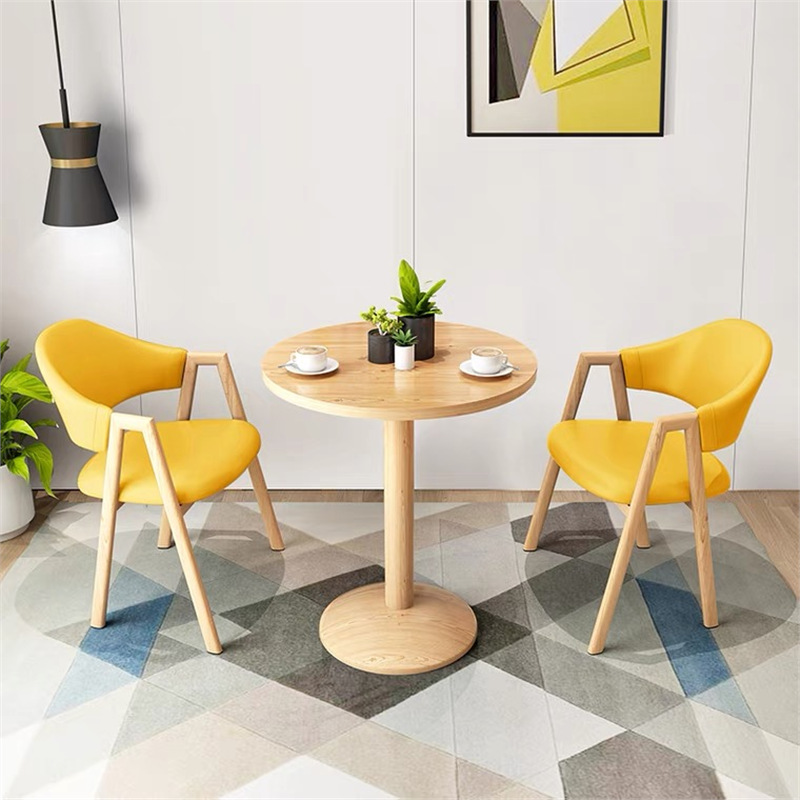 Mesa redonda de 60cm de color amarillo claro y 2 sillas de cuero.