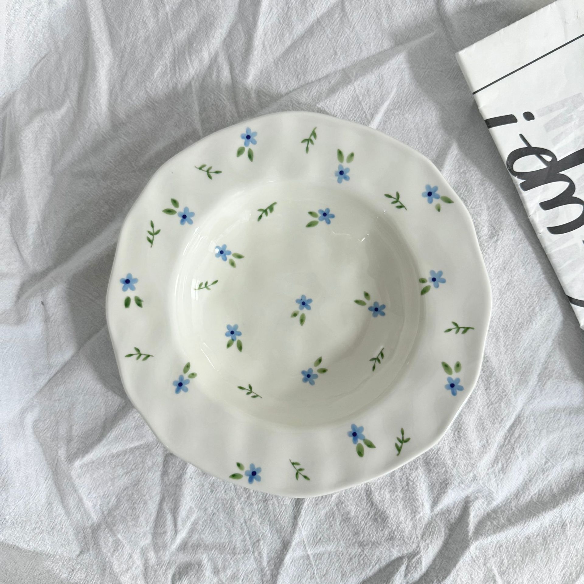 Assiette creuse à main pincée - petit motif floral bleu