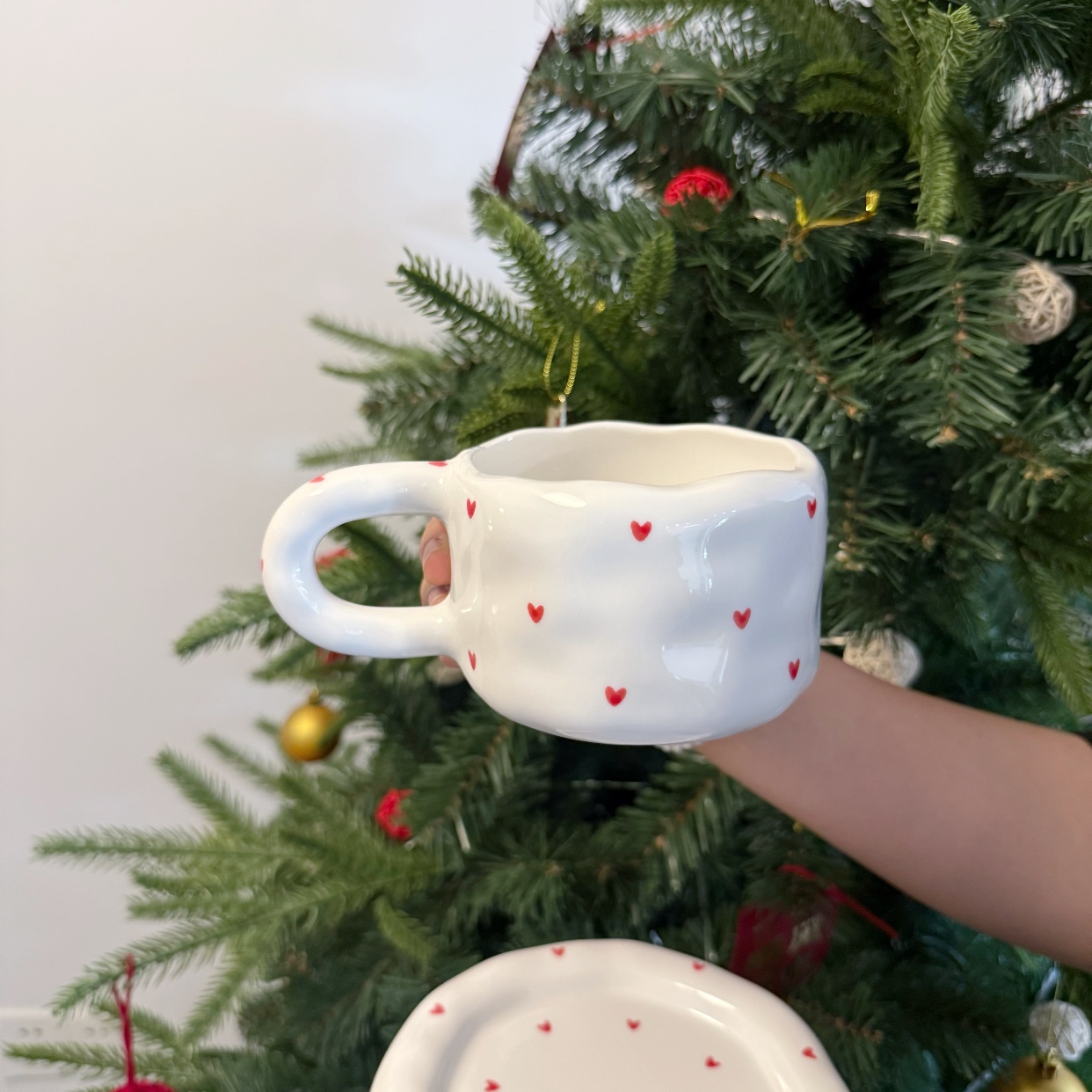 Taza blanca con un pequeño corazón rojo.