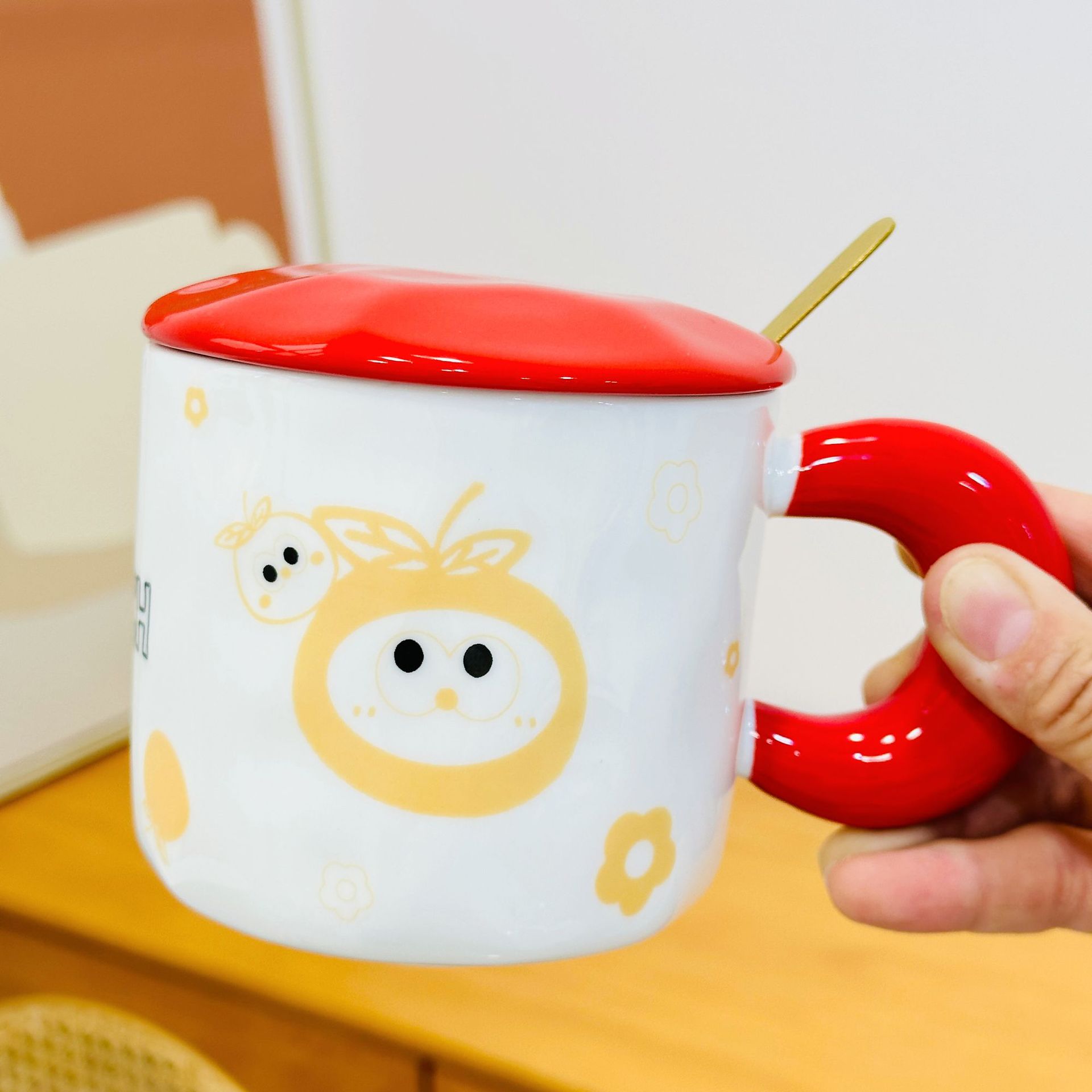 Tasse en céramique rouge orange en haut à gauche avec couvercle et cuillère