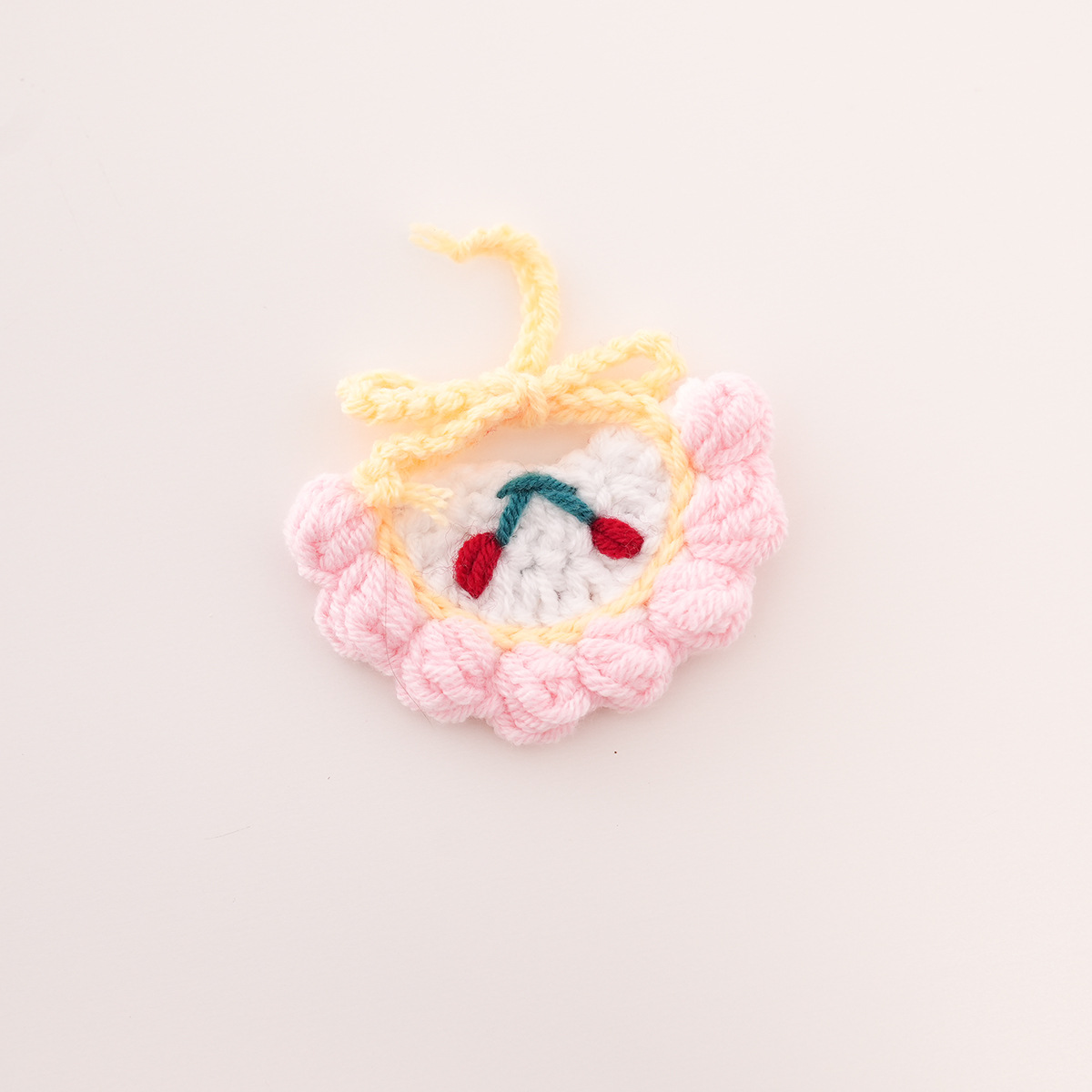 Bib with white background and pink trim, cherry