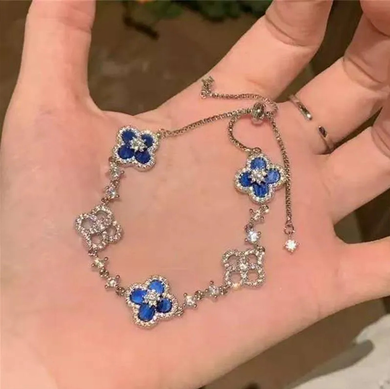 Pulsera de plata con flor de cuatro hojas azul de la suerte.