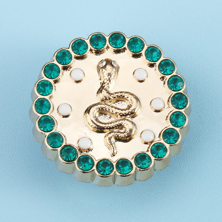 Serpiente de metal con incrustaciones de pequeñas esmeraldas.