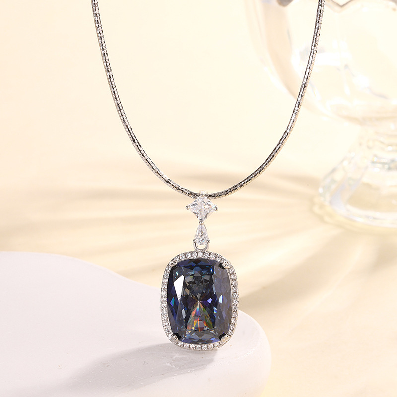 Pendentif nid d'oiseau, plaqué or blanc et bleu, avec chaîne fine.