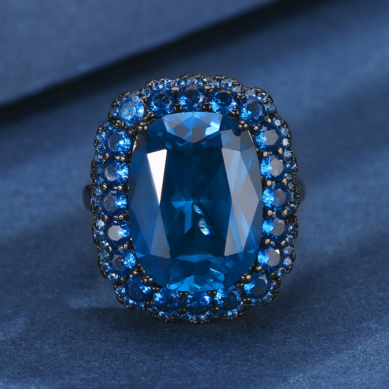 Anillo de cristal azul puntiagudo en oro negro.