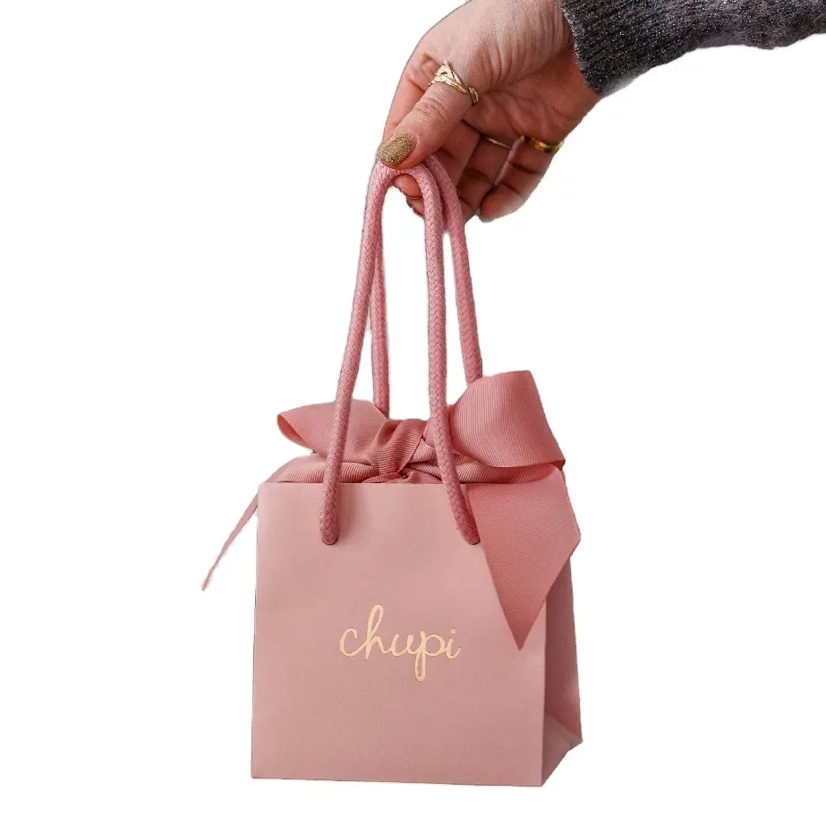 Sacs cadeaux en papier rose avec poignées de ruban élégants et personnalisés avec logo de marque et boutique de vins de luxe