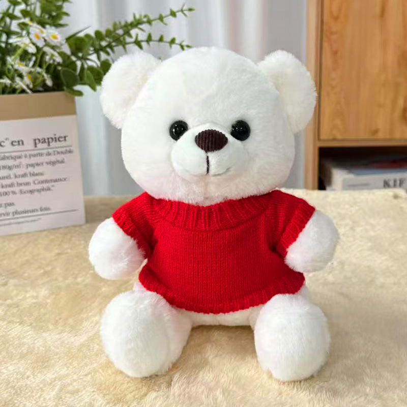 Orsetto di peluche bianco con maglione rosso acceso