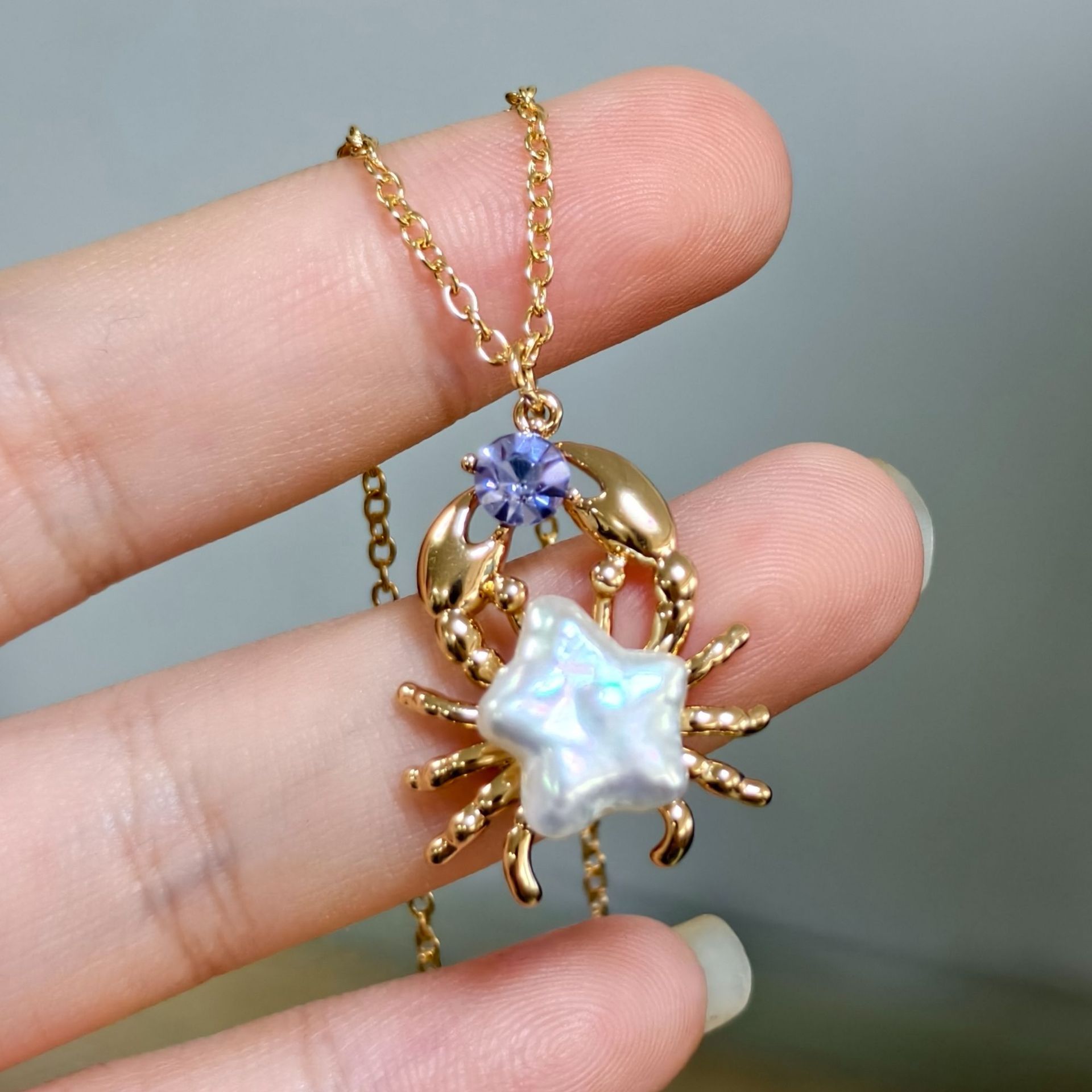 Crabe zircon violet doré (perle naturelle)