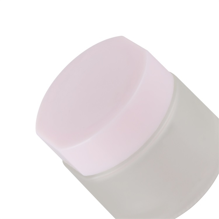 Tarro esmerilado con tapa rosa.