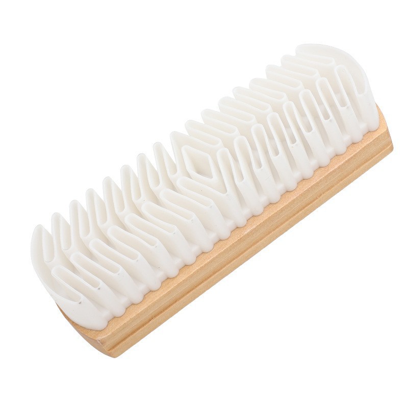 Une brosse à chaussures en daim à une tête et manche en bois