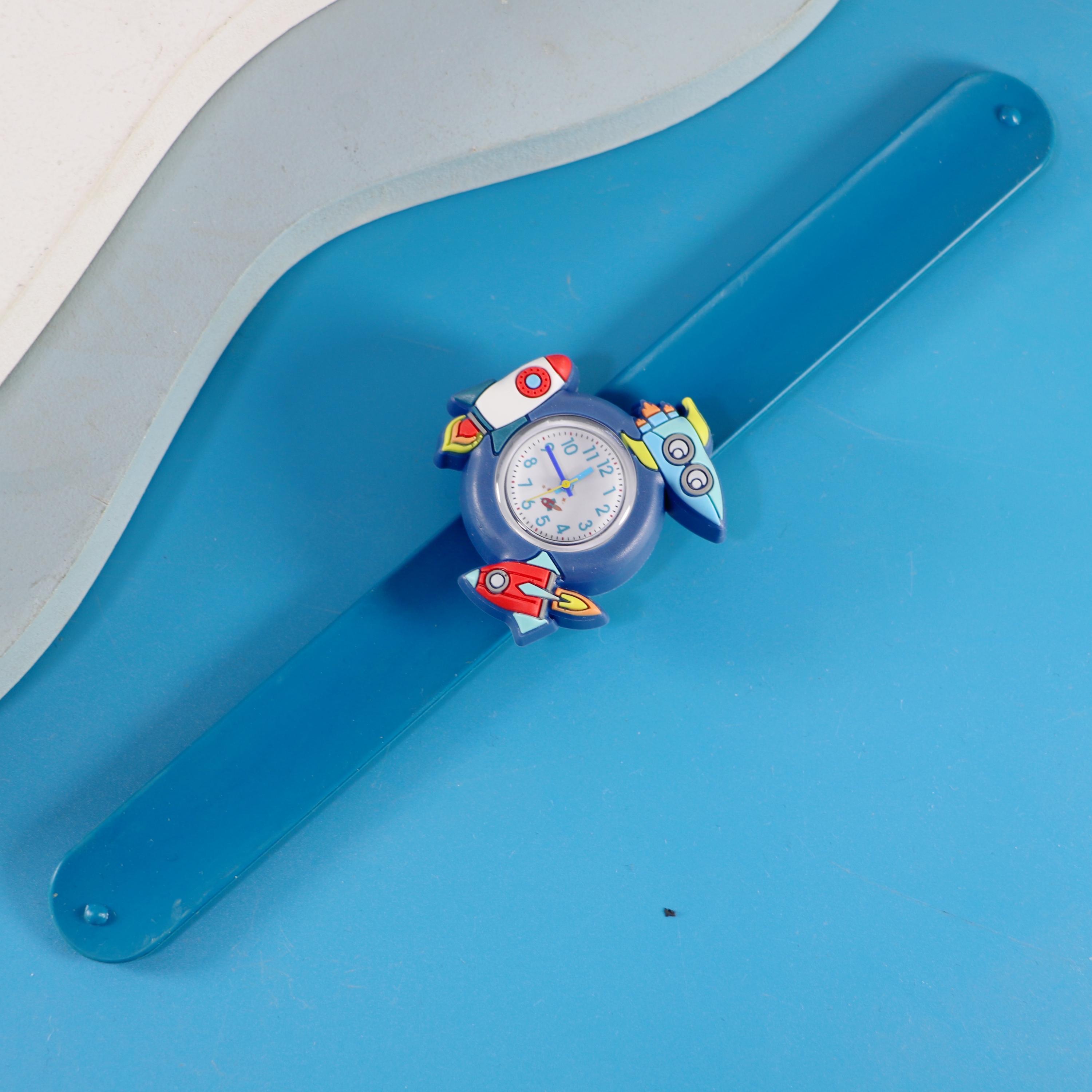Correa de reloj azul con estampado de cohetes.