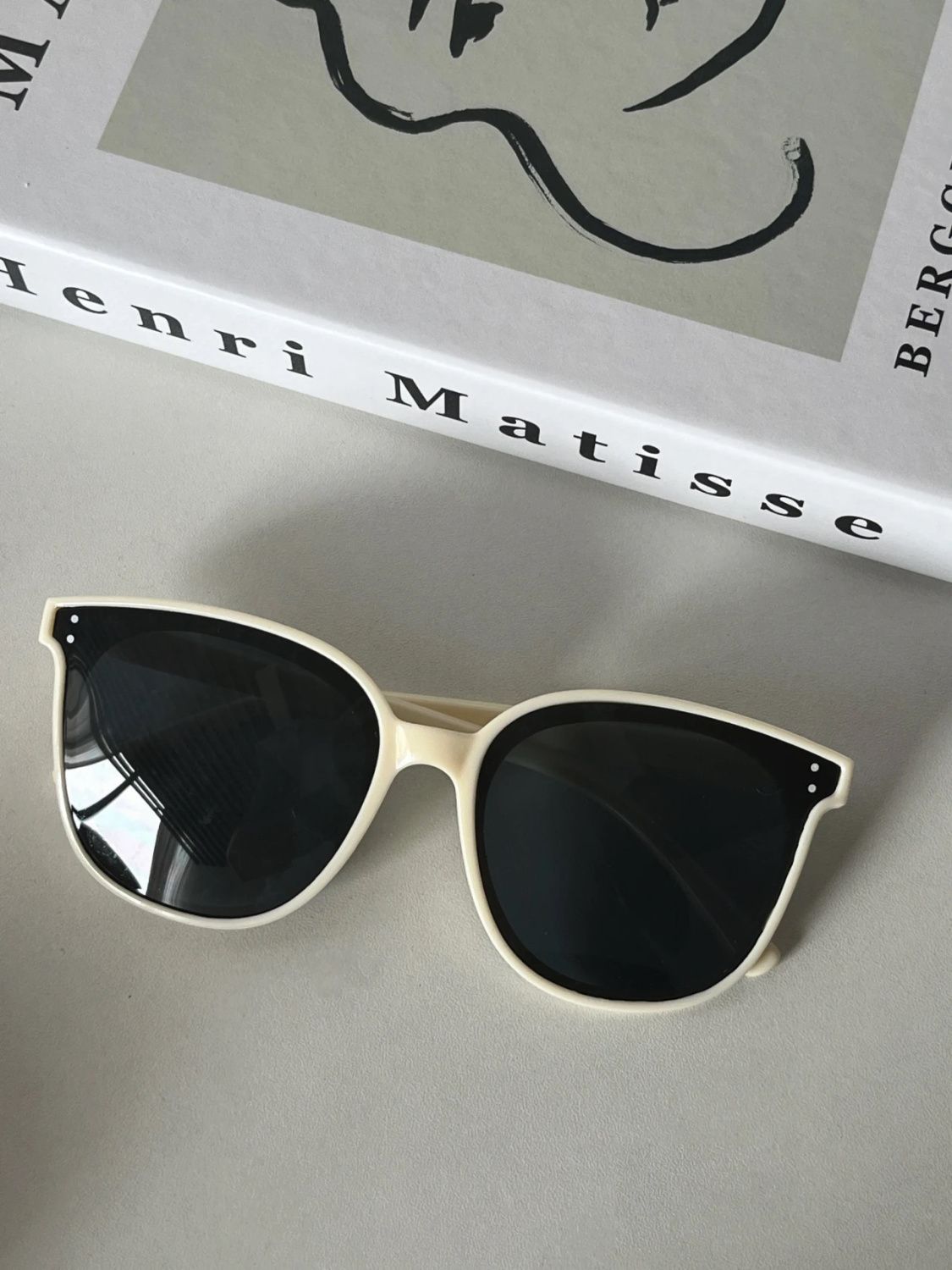 Monture blanche, verres noirs.