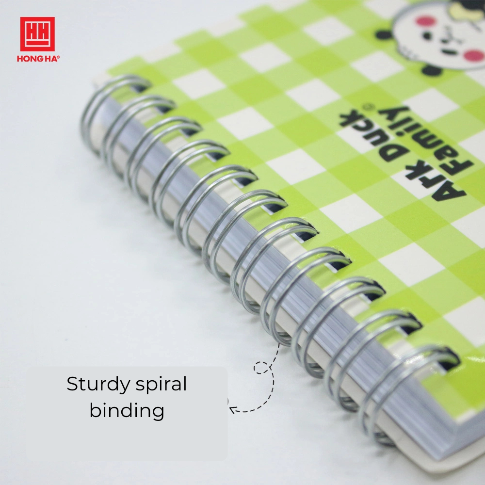 A spiral notebook with a charm