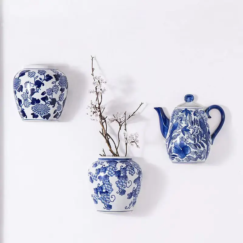 Piccolo vaso di fiori in ceramica blu e bianco a parete che si attacca a una parete