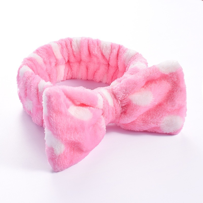 Diadema rosa con lunares blancos y lazo.