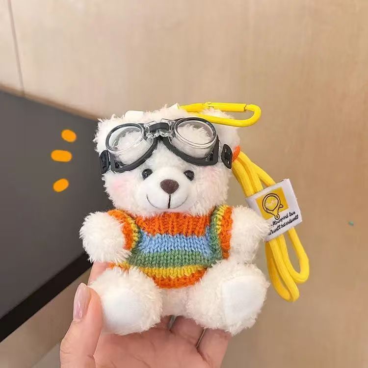 Oso blanco con gafas, suéter arcoíris y cordón amarillo.