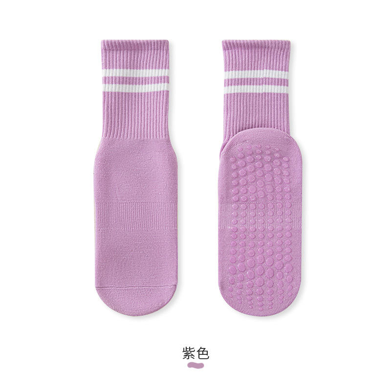 Chaussettes de yoga violettes avec barre de traction intégrée.