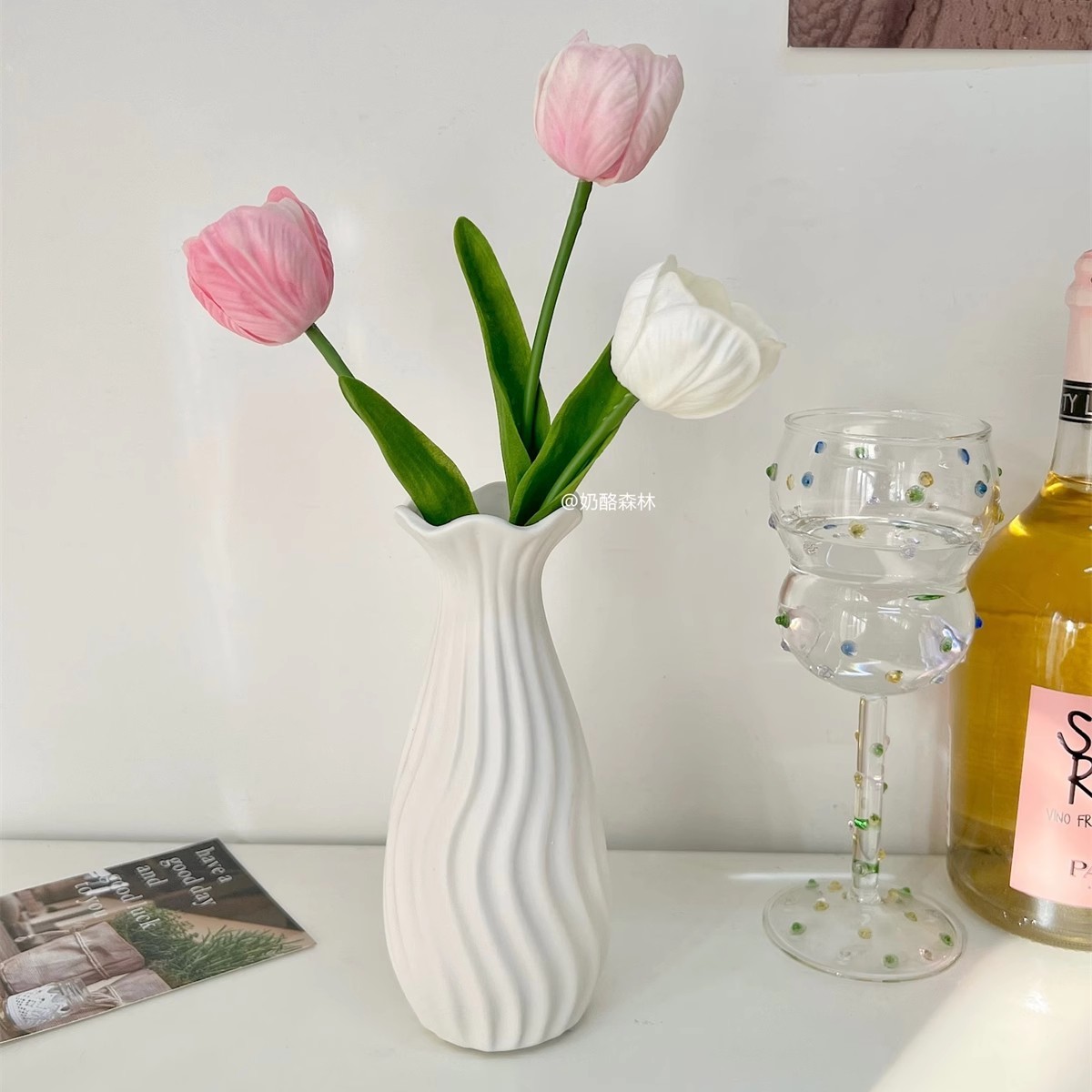2 vases en céramique roses et 1 blanc, en forme de tulipe potelée, avec motif de poissons.