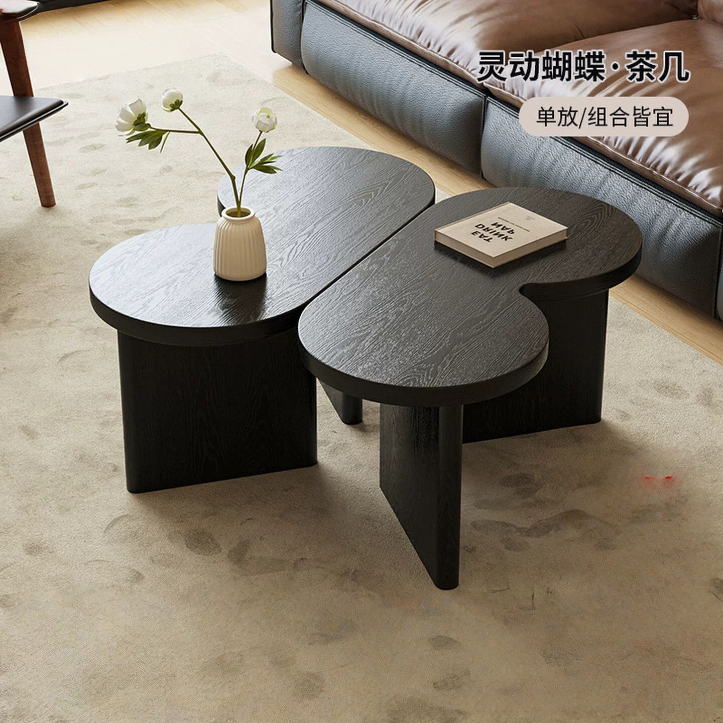 (A pair of black butterfly-shaped unpainted coffee tables)