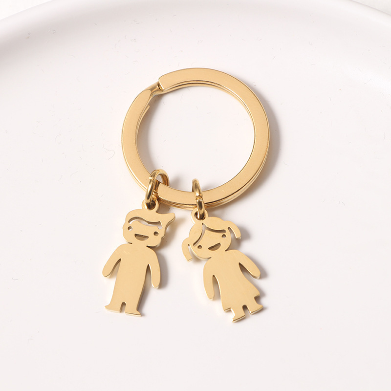 Porte-clés doré avec poupée et inscription d'une lettre.