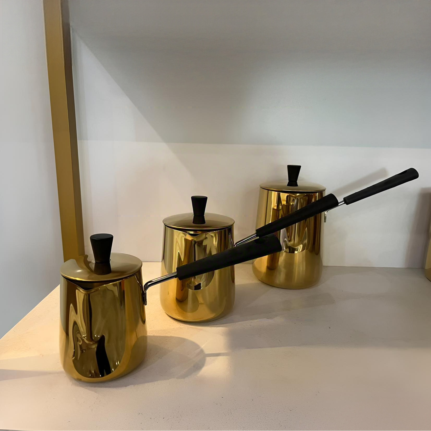 Tasse à lait à anse noire (surface lisse) avec couvercle doré.