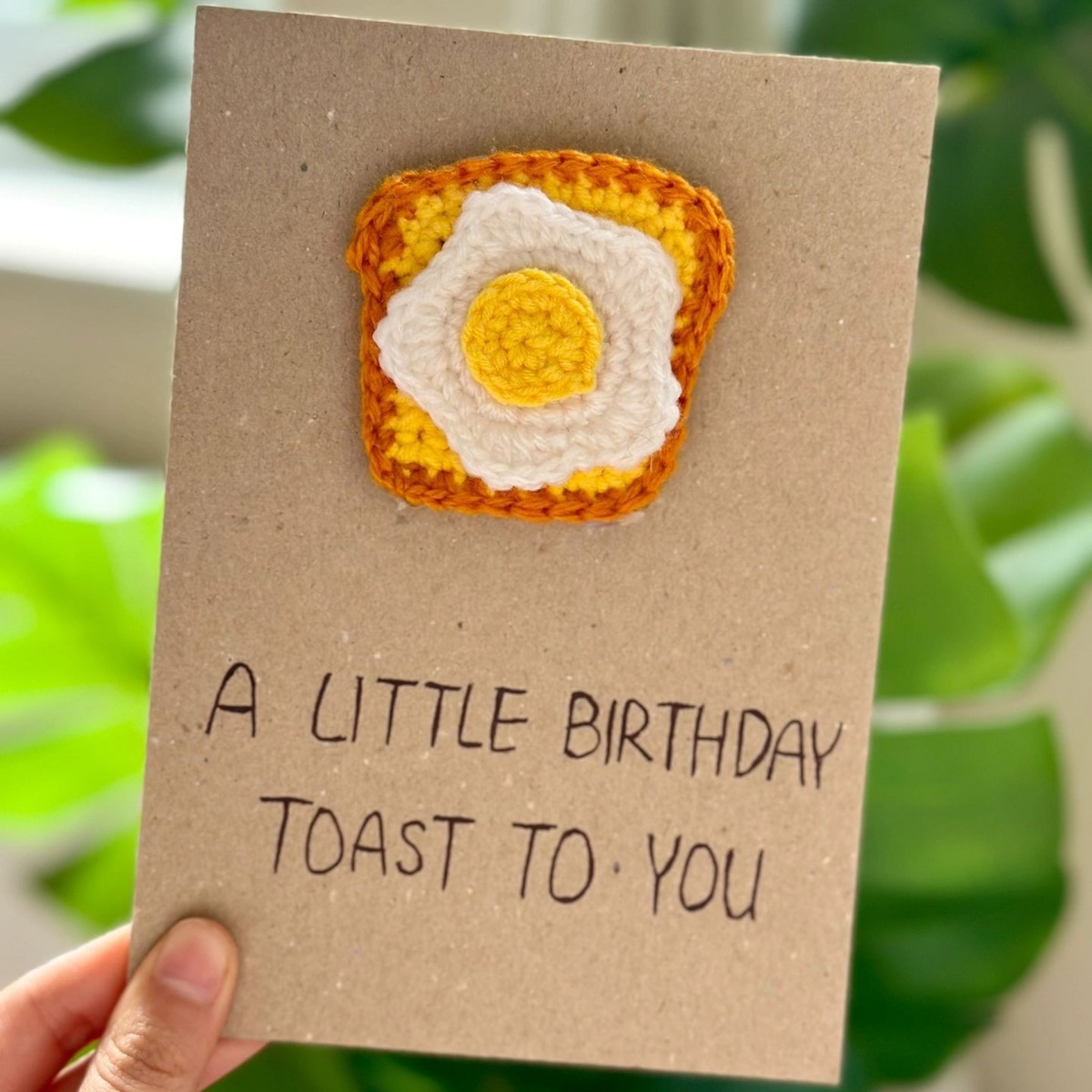 Tarjeta de cumpleaños con diseño de tostada con huevo frito amarillo.
