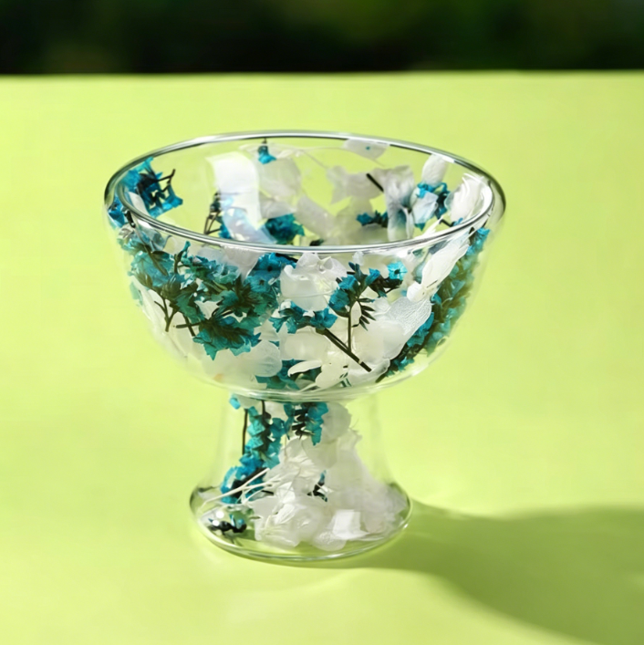 Coupe à glace avec tiges florales bleues et pétales blancs