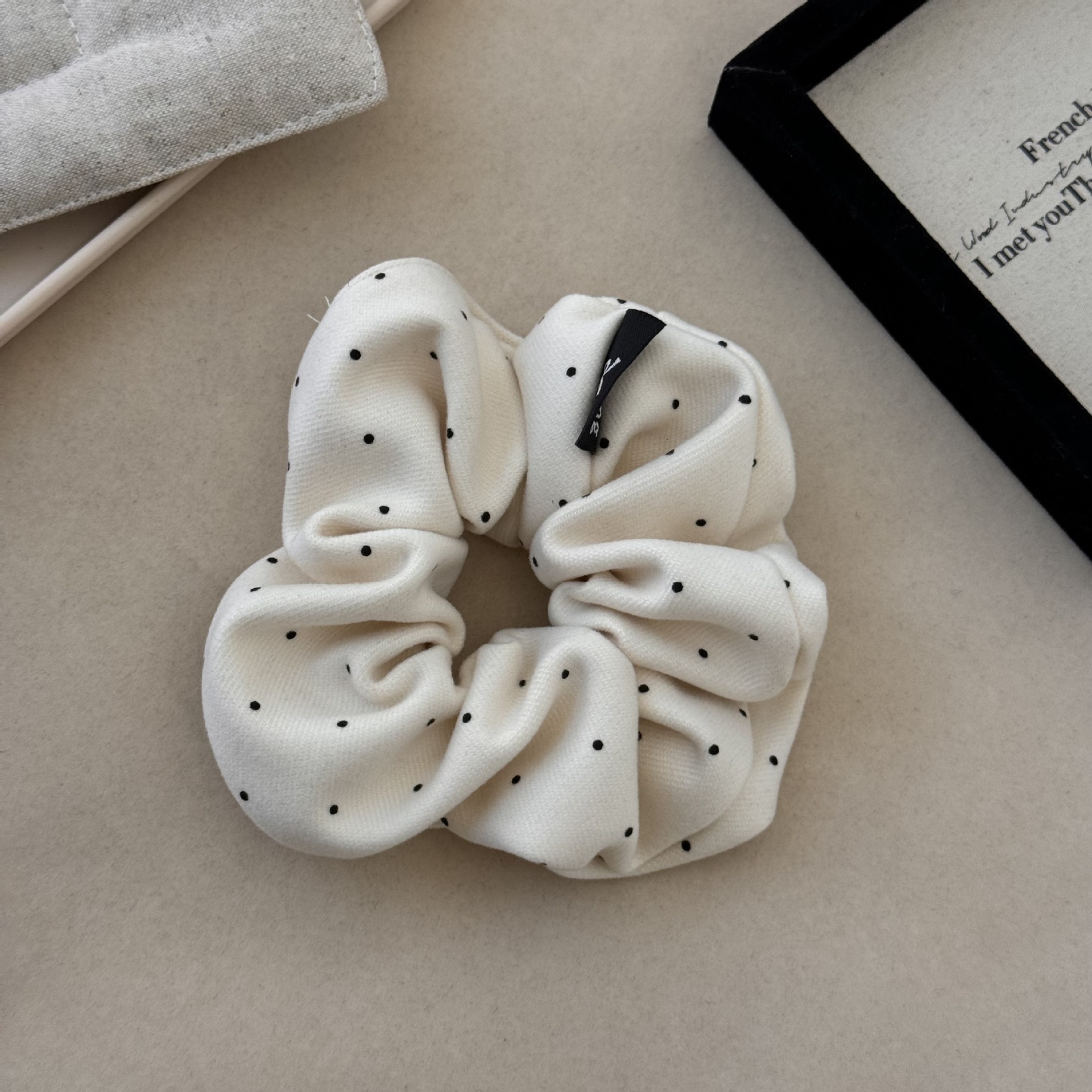 Anillo para el cabello con diseño de ondas beige y lunares.