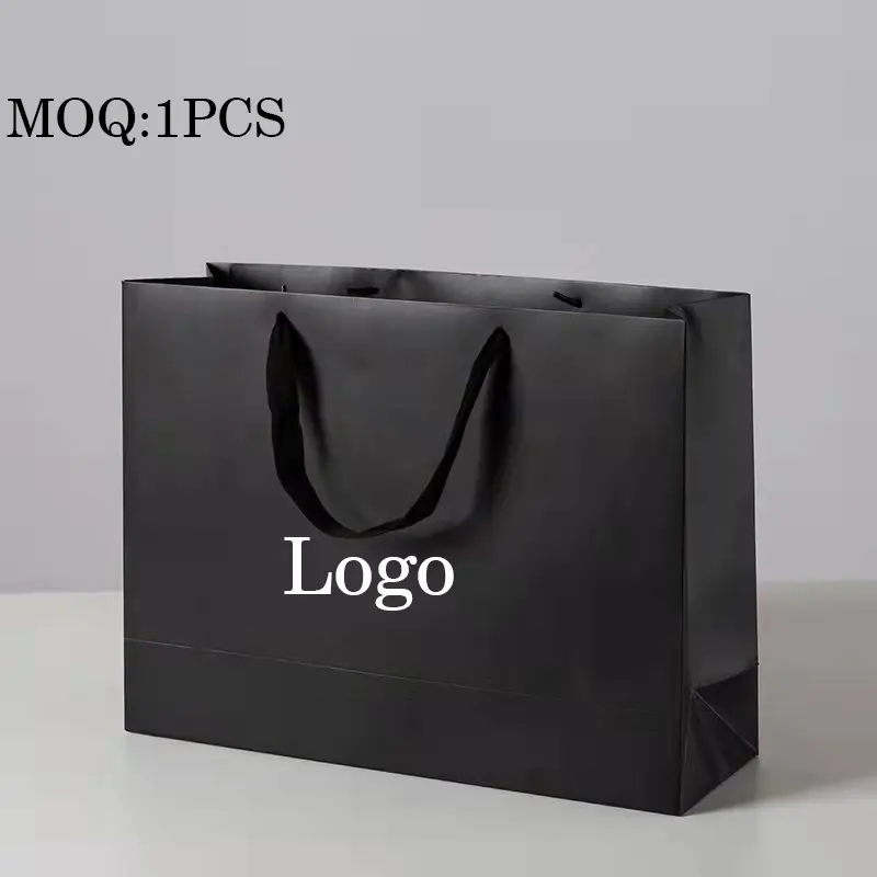 Bolsa de papel de regalo negra de lujo, logotipo impreso personalizado para zapatos, ropa, compras, regalo de boda, embalaje de joyería con asas de cinta