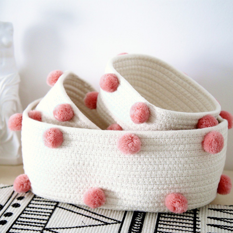 A set of pink pom-poms (one large and two small)