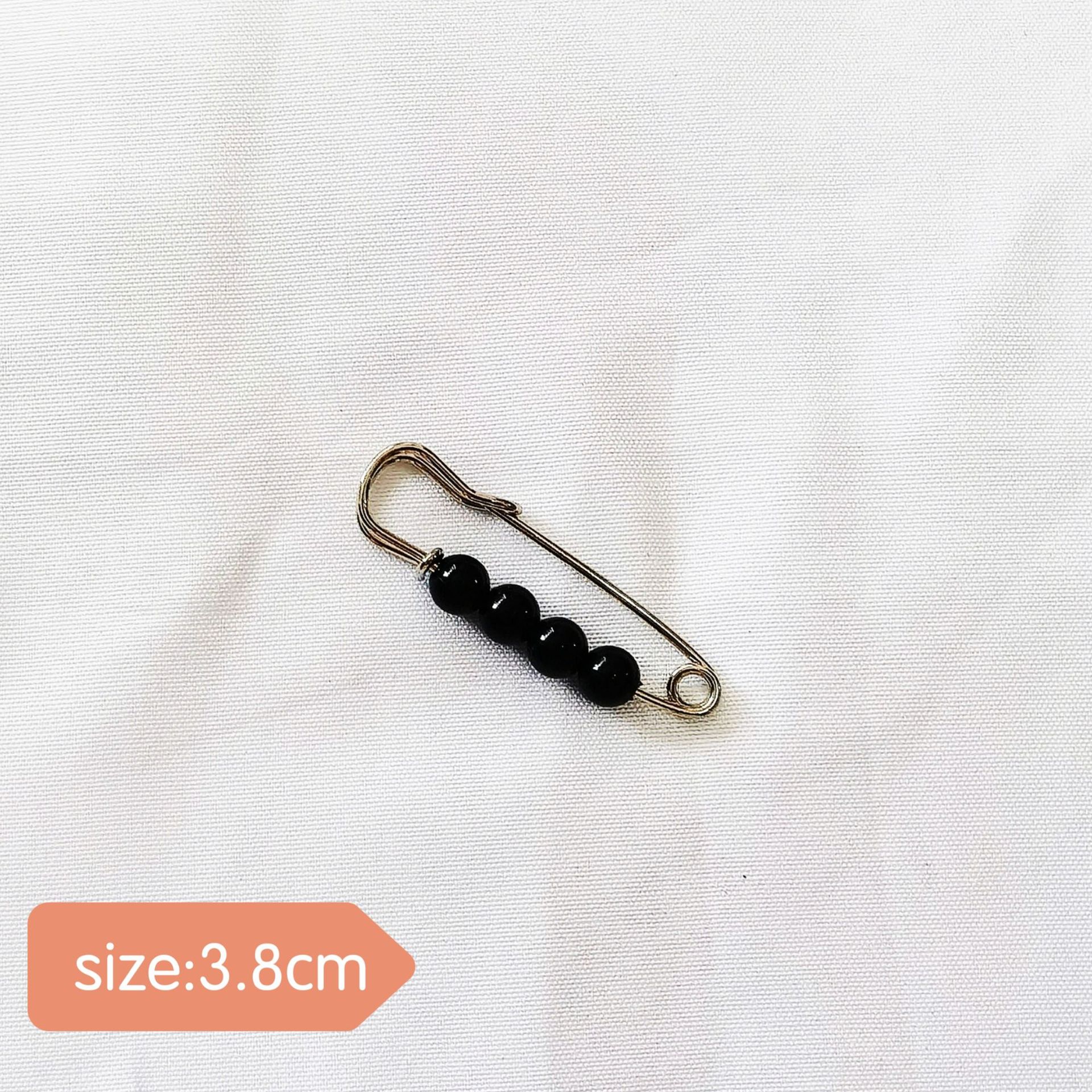 Pin 14#Cuatro cuentas negras, aguja de plata, 3.8 cm.