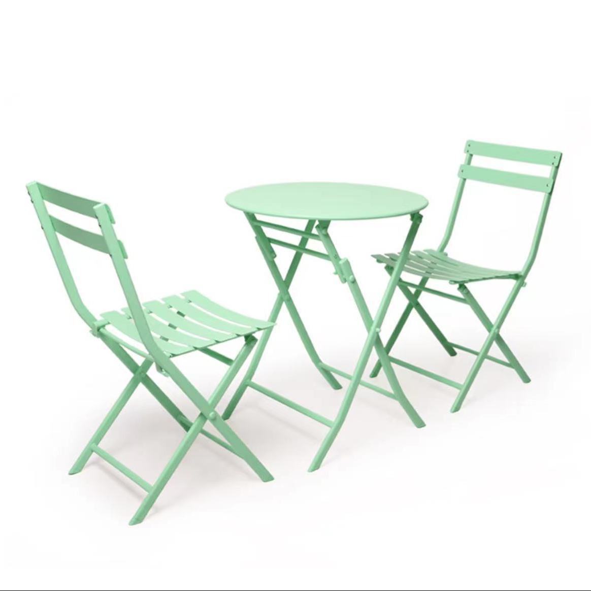 Ensemble comprenant 2 chaises en fer forgé vert et 1 table ronde pliante.