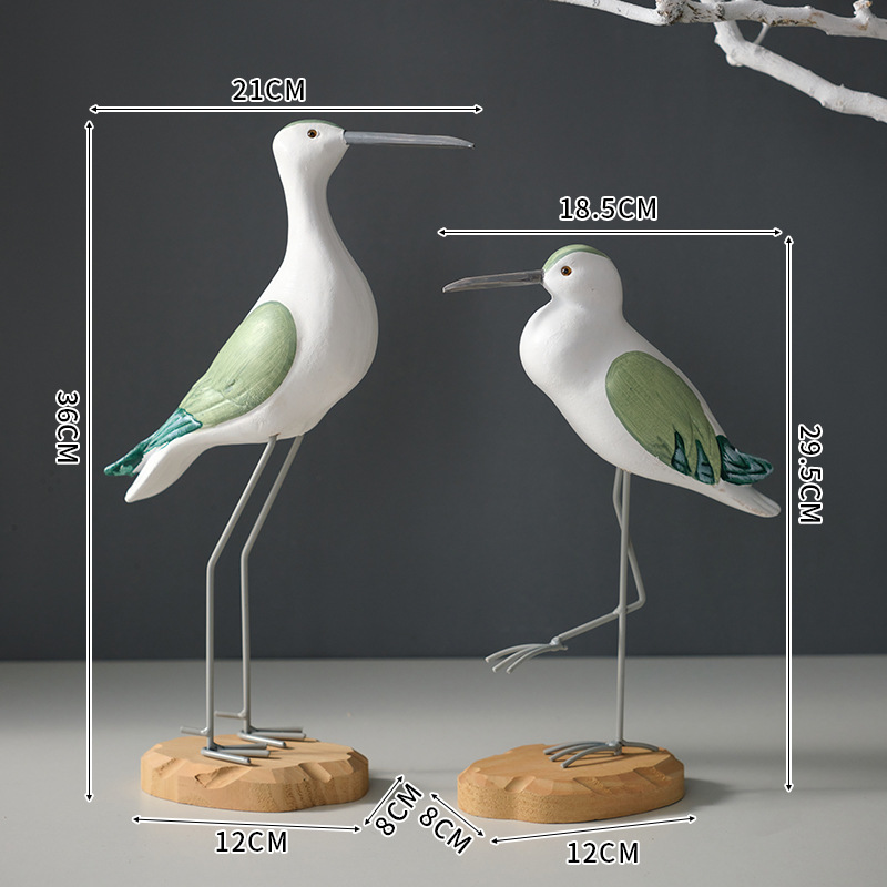 A set of round-carved green and white bird ornaments