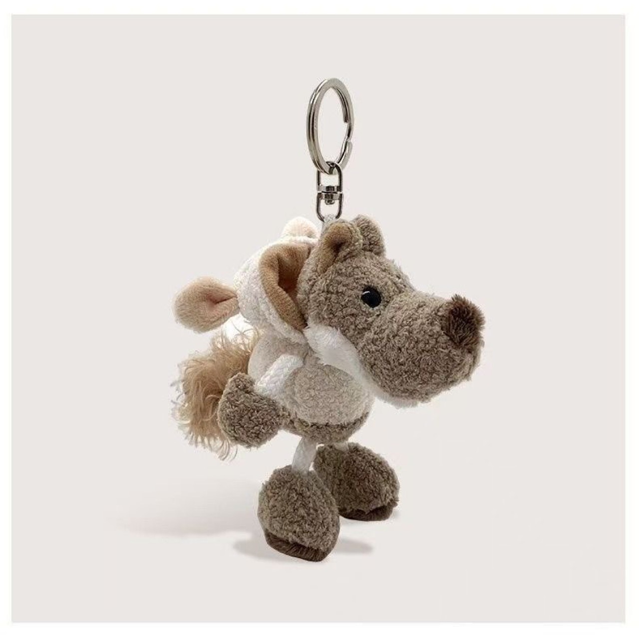 La petite poupée loup portant un manteau à capuche blanc crème
