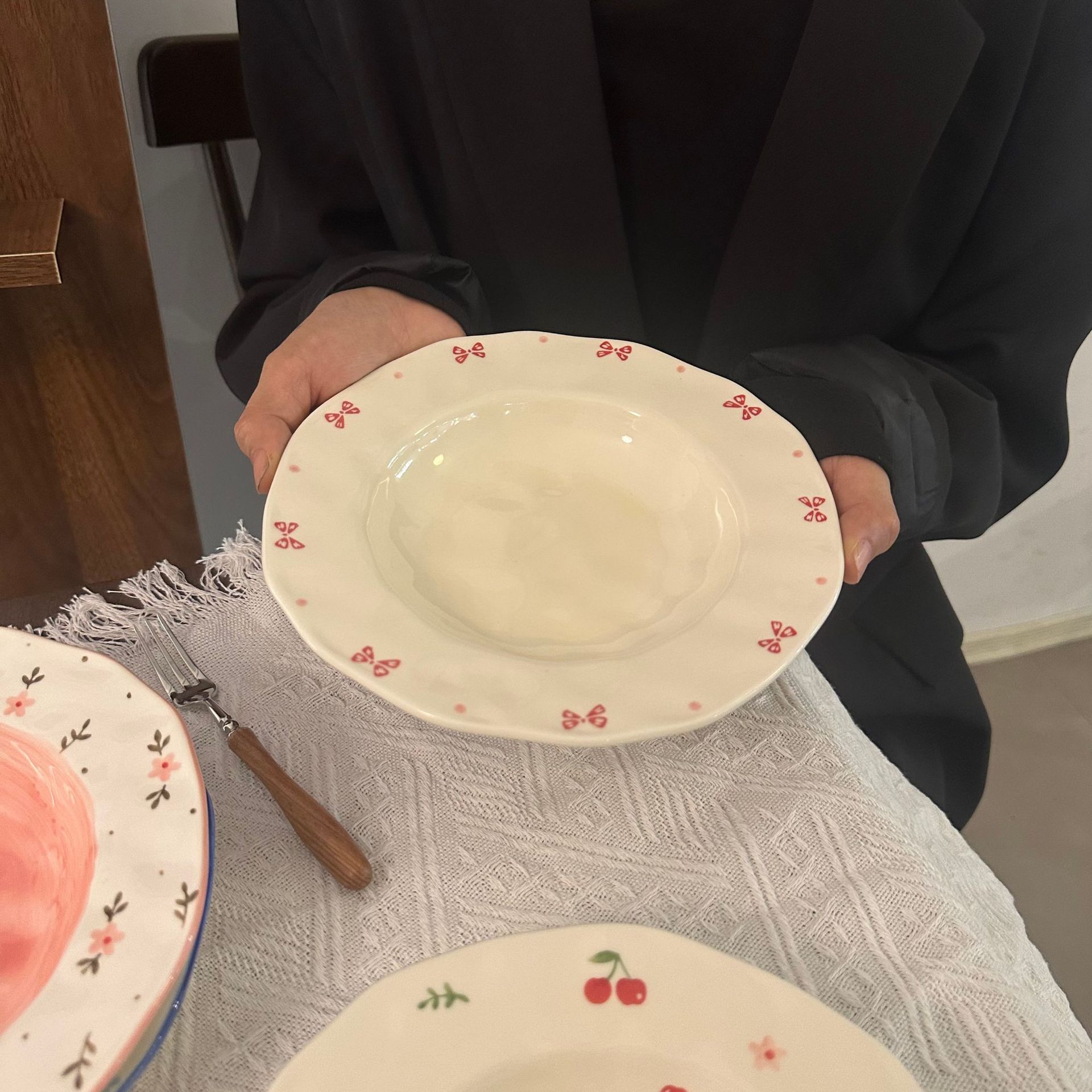 Noeud papillon rose assiette profonde pincé à la main