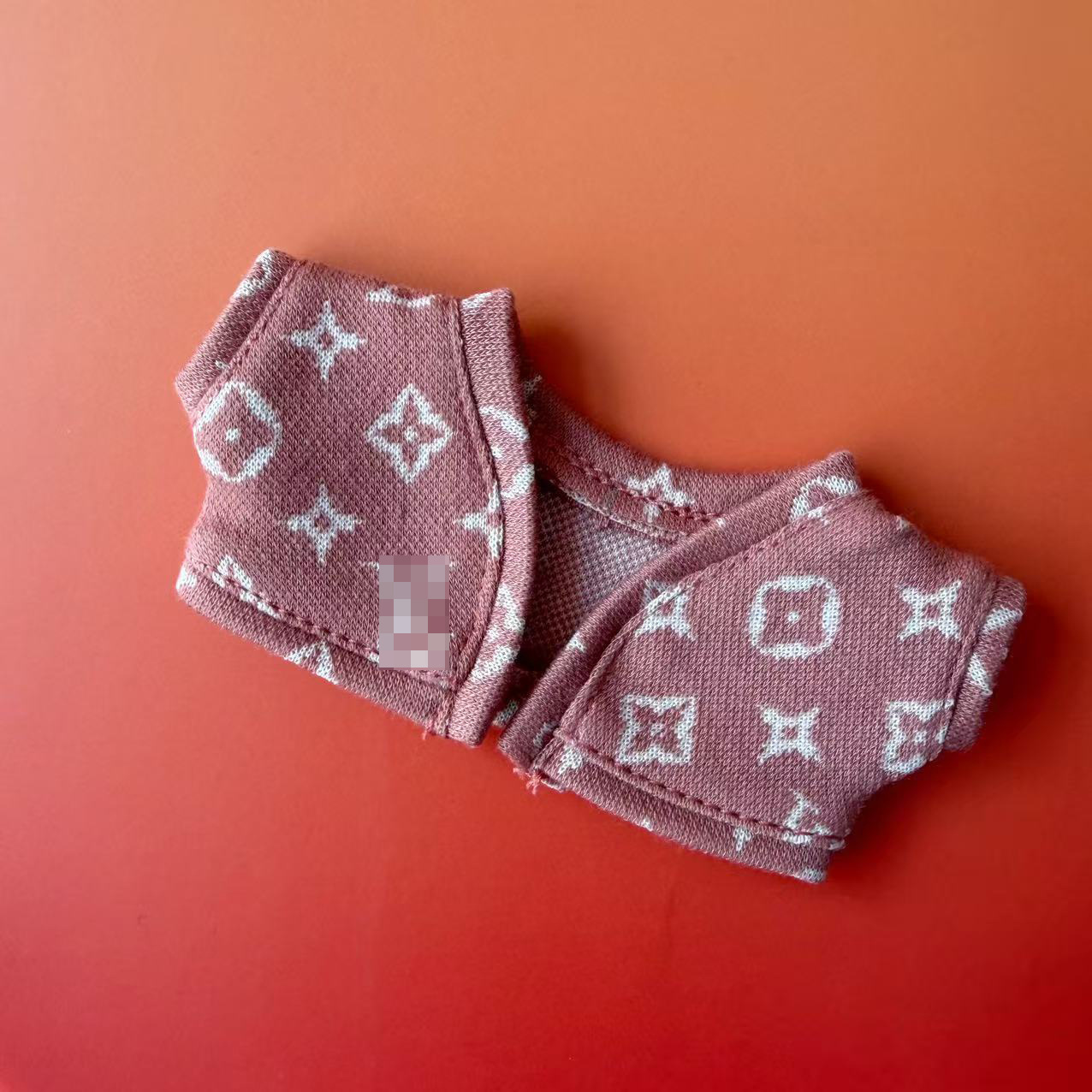 Cárdigan rosa con letras del alfabeto.