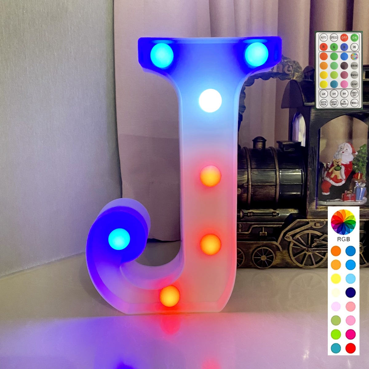 Lettre colorée synchronisée avec télécommande sur fond blanc : j