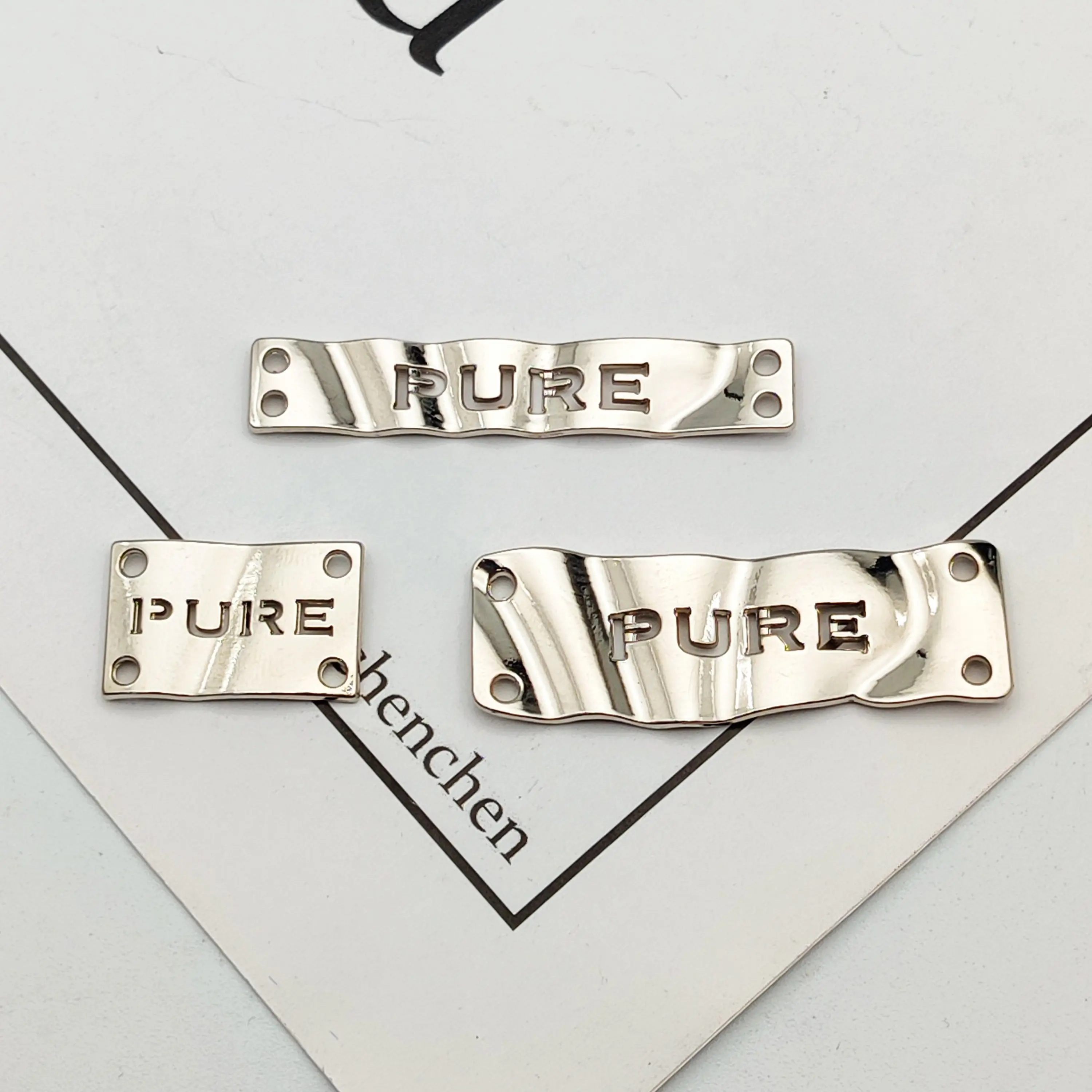 Etiqueta de logotipo de Metal de 4 agujeros, placa de Metal personalizada para ropa o bolsas