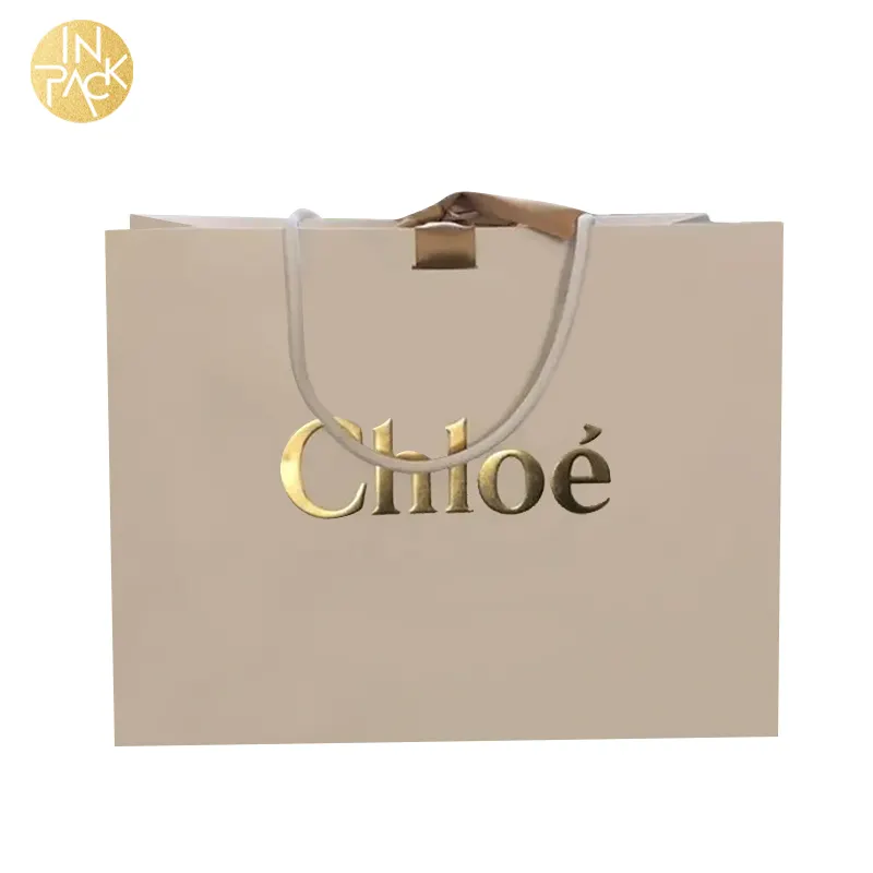 En paquete al por mayor logotipo personalizado en relieve bolsas de regalo a granel al por menor Boutique de embalaje bolsa de papel de compras