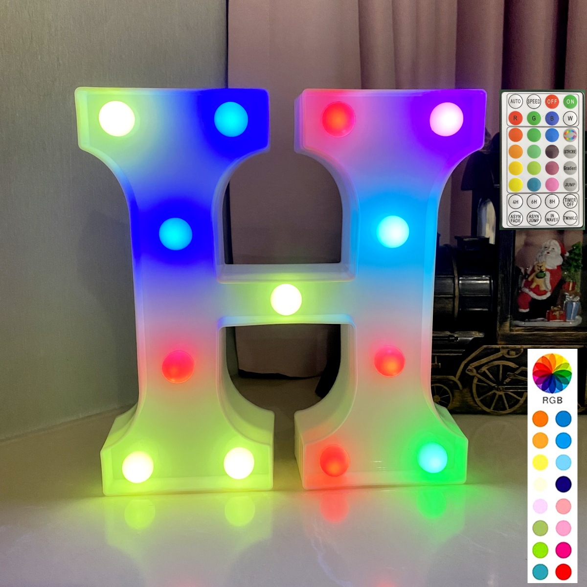 Lettre colorée synchronisée avec télécommande sur fond blanc : h