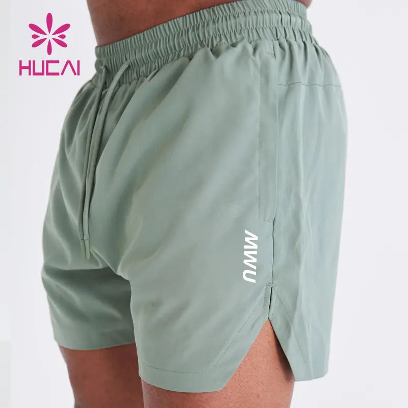 HUCAI özel logo polyester spandex atletik naylon kısa bölünmüş Hem kesim egzersiz erkek spor spor şort
